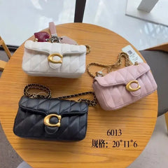 Luxury women's crossbody bag collection featuring premium leather in white, pink, and black colors on a wooden table.