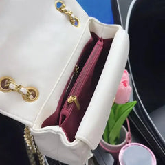 Luxury women's crossbody bag interior view showing zipper pocket and elegant design with gold detailing.