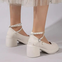 Elegant cross strap high heel pumps shown from behind, featuring a stylish design with block heels and a chic pearl strap.