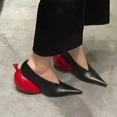 Women's black leather pointed toe pumps with unique red balloon-shaped heel for a bold fashion statement.