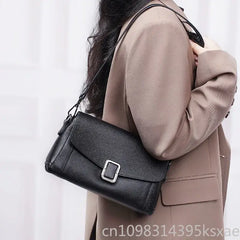 Chic minimalist leather crossbody bag worn by a woman with a stylish outfit.