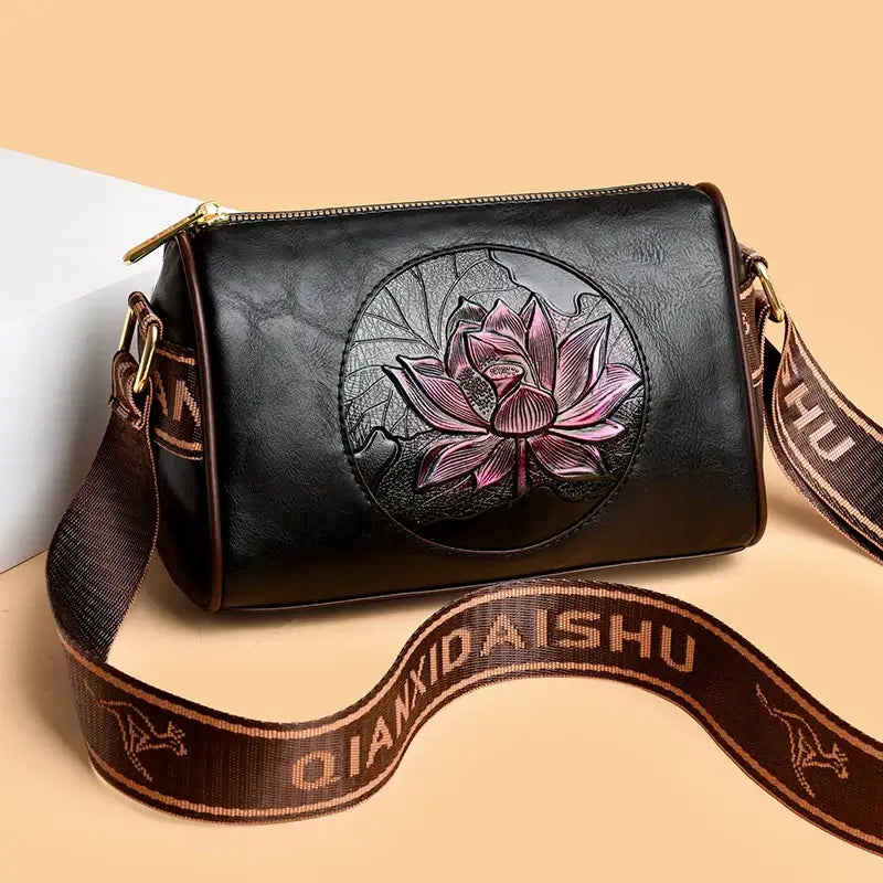 women's leather crossbody handbag featuring a floral design in a stylish black color.