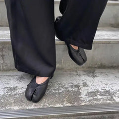 luxury split toe women's pumps worn by a model on steps, showcasing elegant design and high heel features.