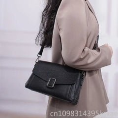 Chic minimalist leather crossbody bag worn by a model in a stylish outfit, showcasing its sleek design and versatility.