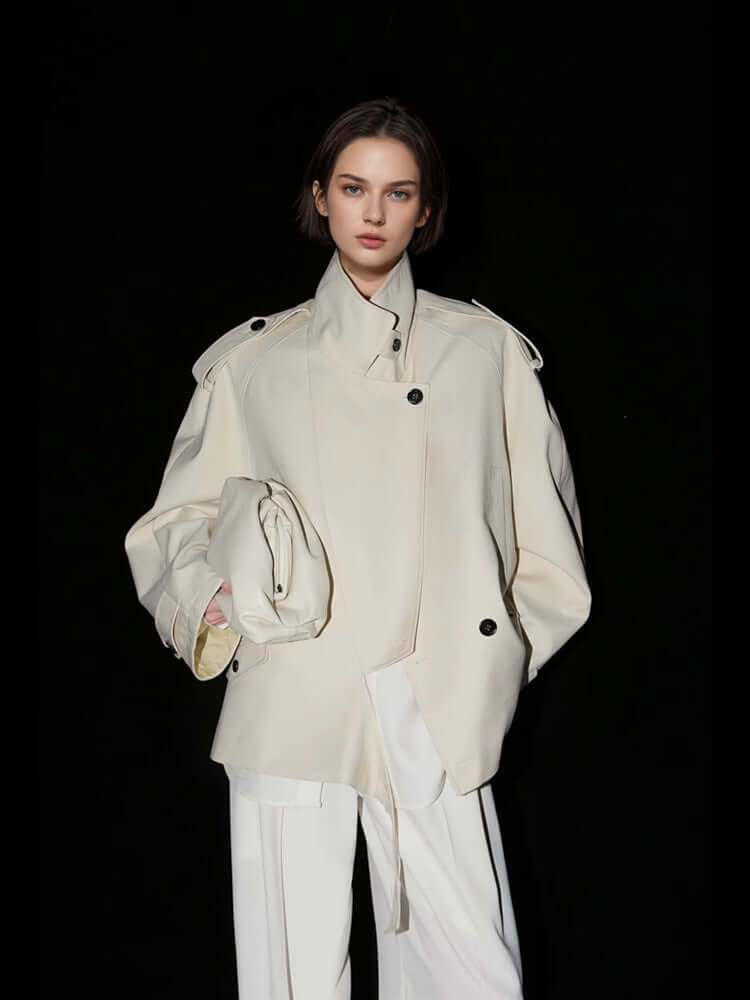 Loose Wide Retro British Trench Coat in white worn by model against black background.